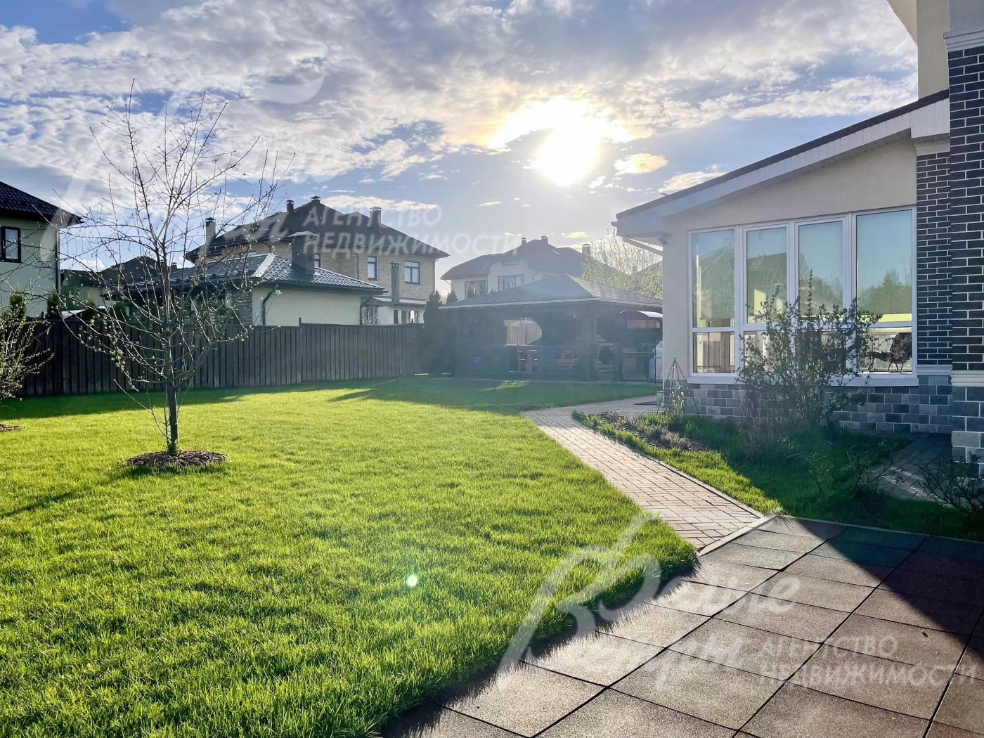 Ухоженный газон на участке, дорожки.