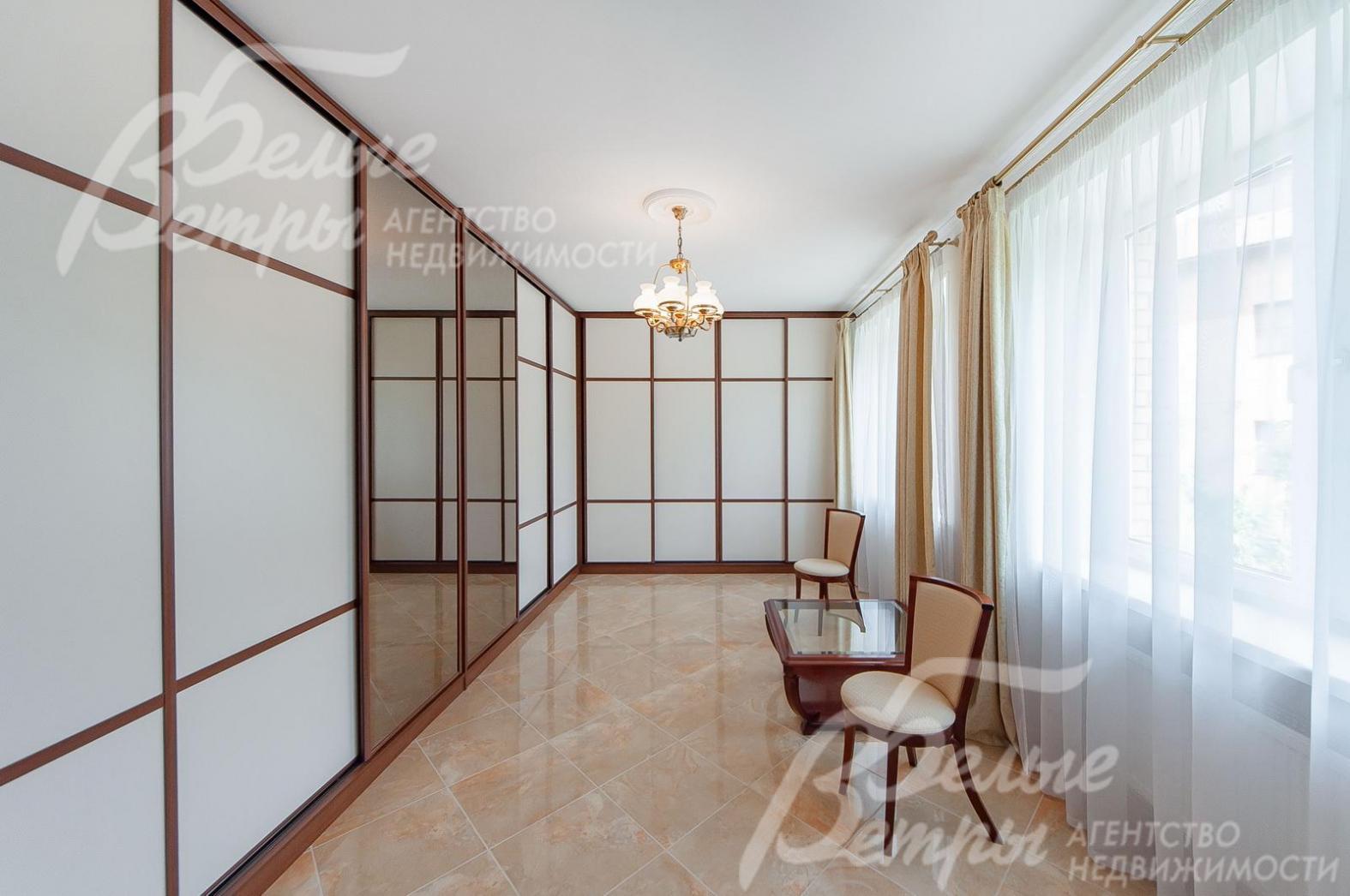 Большая гардеробная с различными системами хранения.