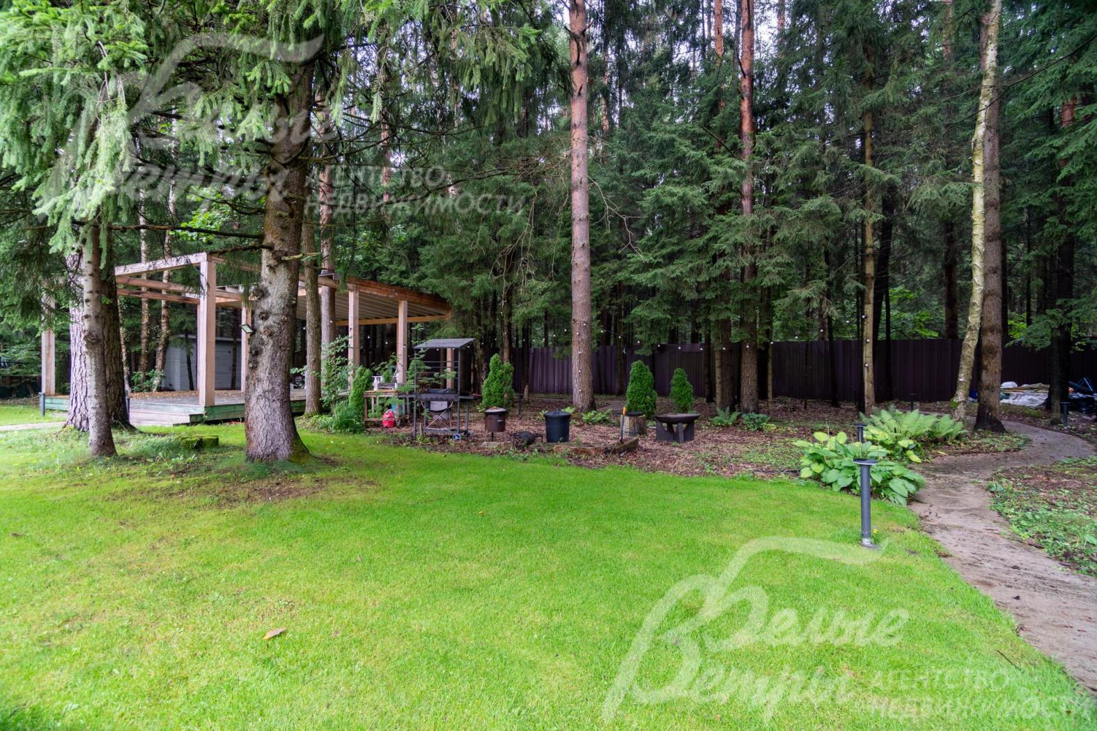 На участке есть беседка и небольшая зона отдыха в тени лесных деревьев