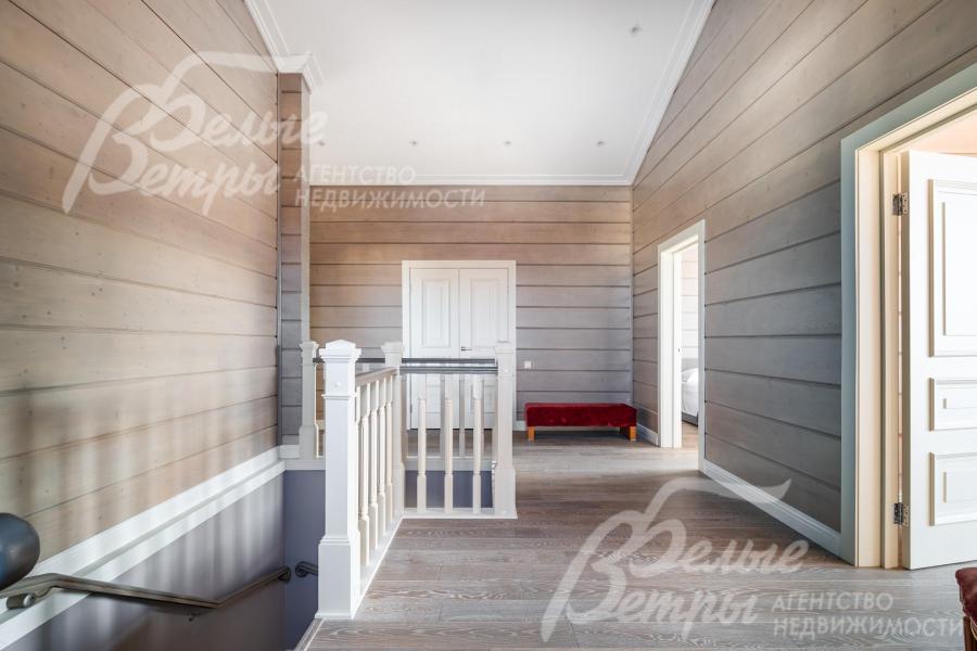 Холл второго этажа: стены оформлены тонированным брусом с противопожарной обработкой и покрытием премиальной краской Sikkens