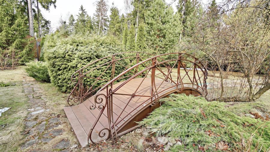 По участку сделан сухой ручей с мостиком