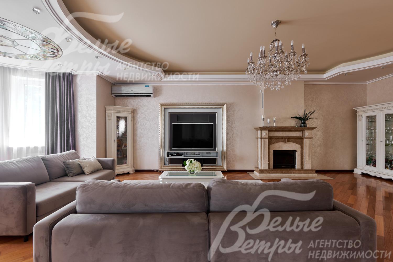 В гостиной установлен широкоформатный телевизор напротив диванной группы