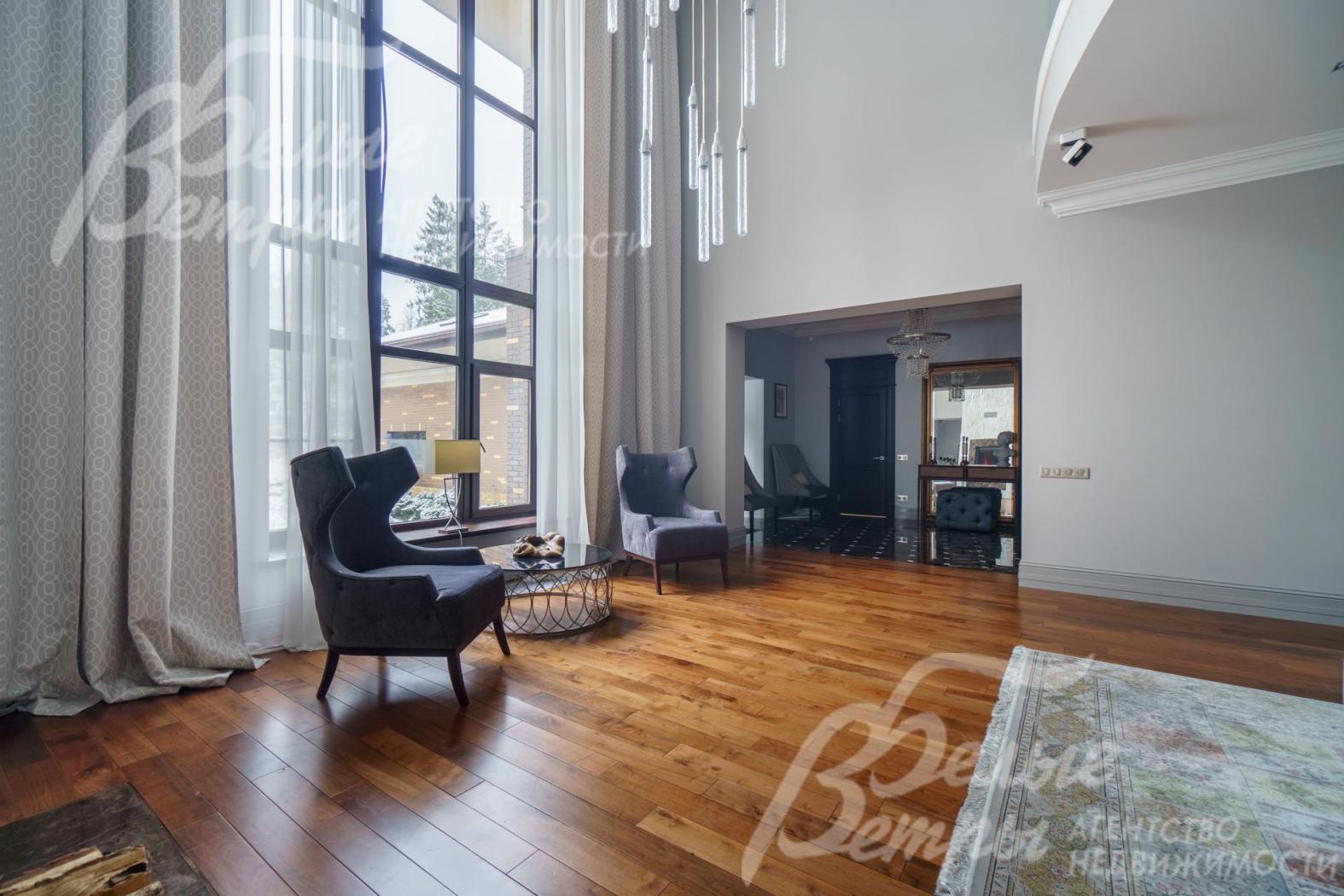 Огромное панорамное окно открывает вид на лесной участок.