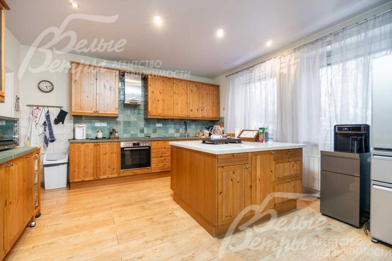 На кухне располагается гарнитур из массива дерева с островом и встроенной бытовой техникой BOSCH