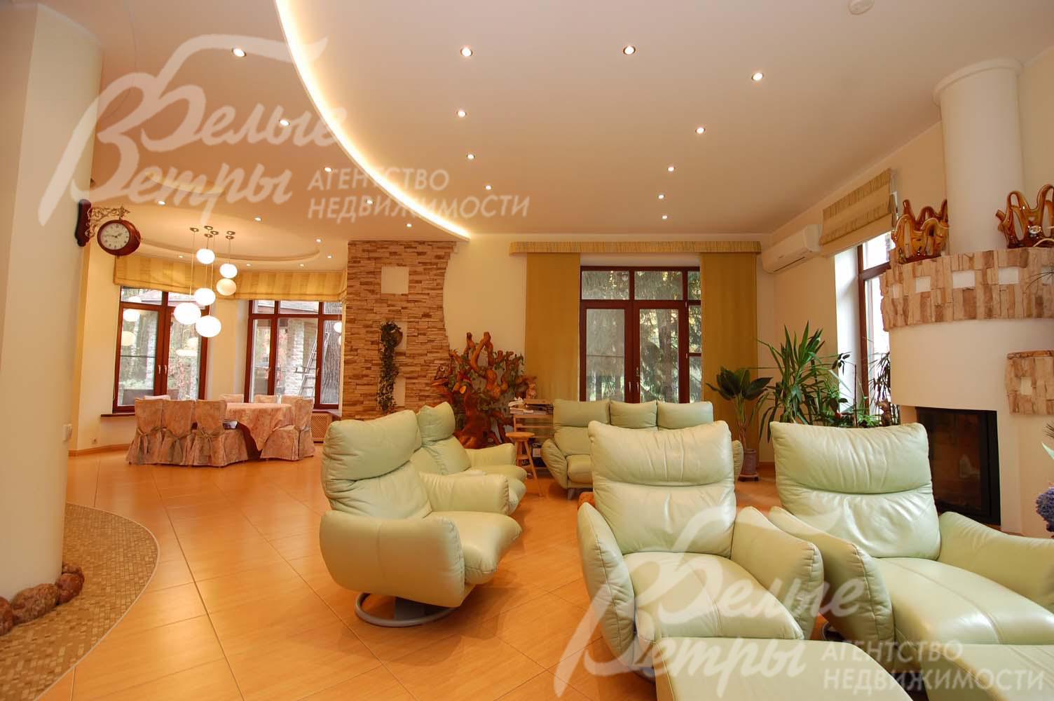 Гостиная 40 кв.м с камином. Тут разместились удобные кожаные вращающиеся кресла, благодаря которым можно легко выбрать, любоваться ли огнем в камине или смотреть интересный фильм по телевизору, или же наблюдать за играющими  в гостиной детьми.