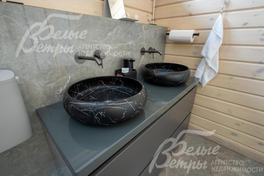 В санузле при мастер-спальне - две эффектные каменные раковины "под чёрный мрамор" на тумбе