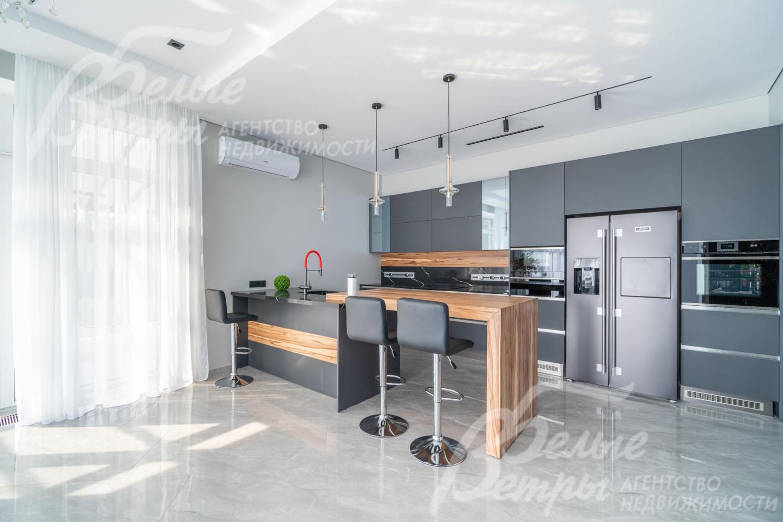 Кухня с функциональным островом-стойкой со шпонированной столешницей и барными стульями