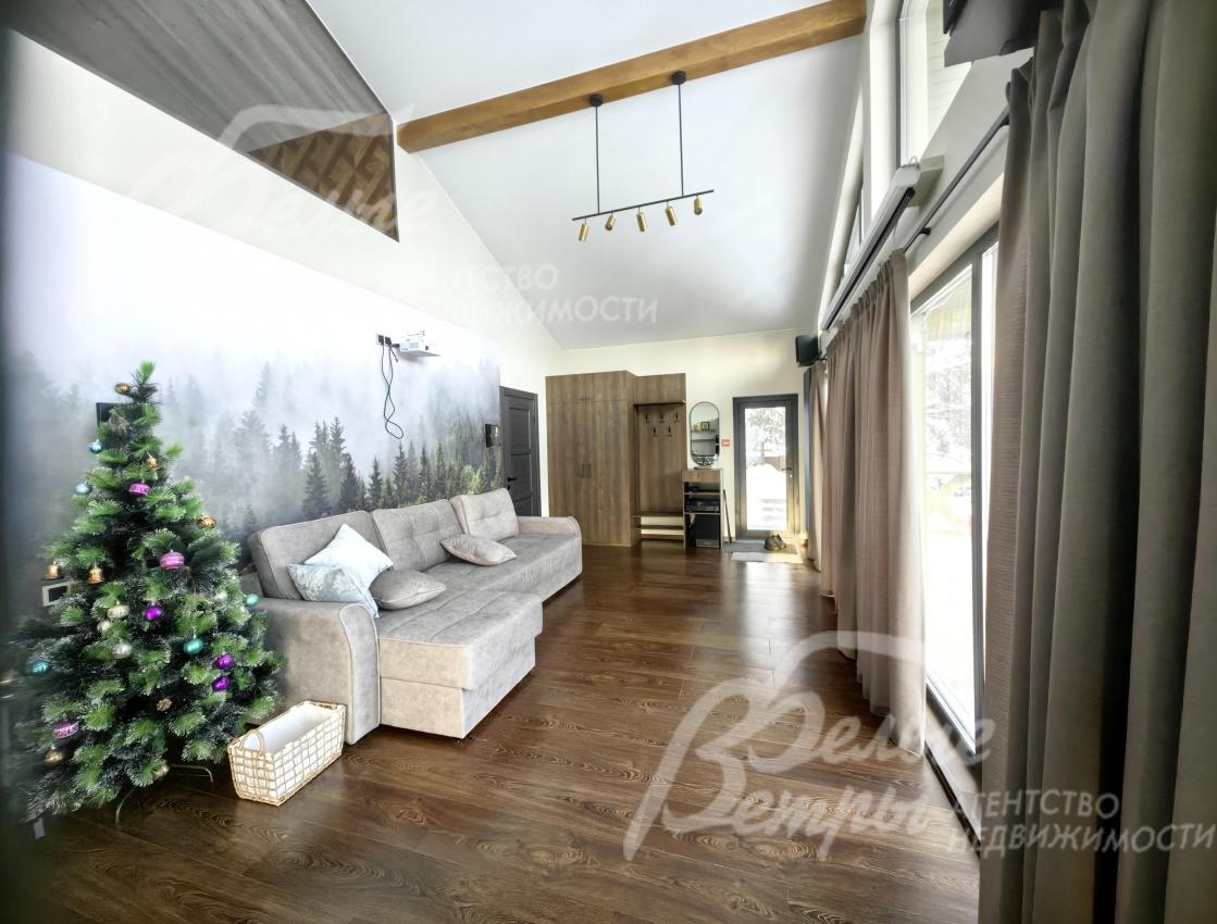 Просторная гостиная с высоким потолком и панорамными окнами