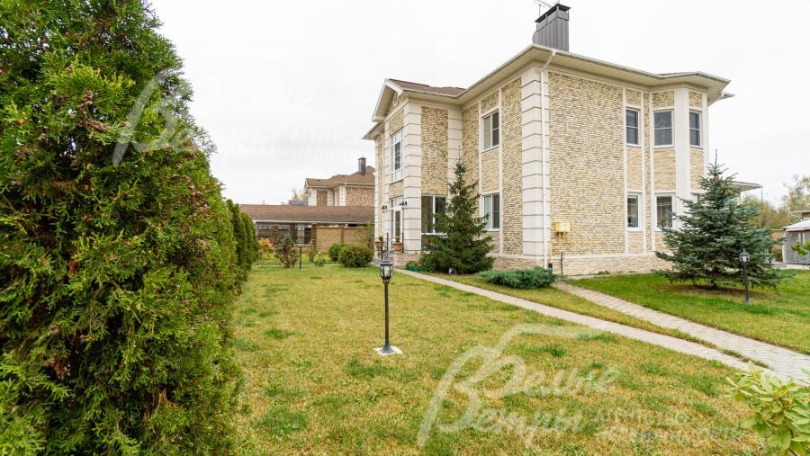 На участке уложен рулонный газон, высажены декоративные кустарники