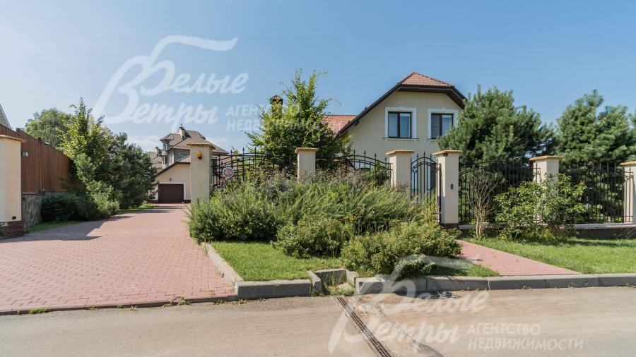 Участок огорожен спереди прозрачным, кованым забором на каменных столбах с бетонным цоколем