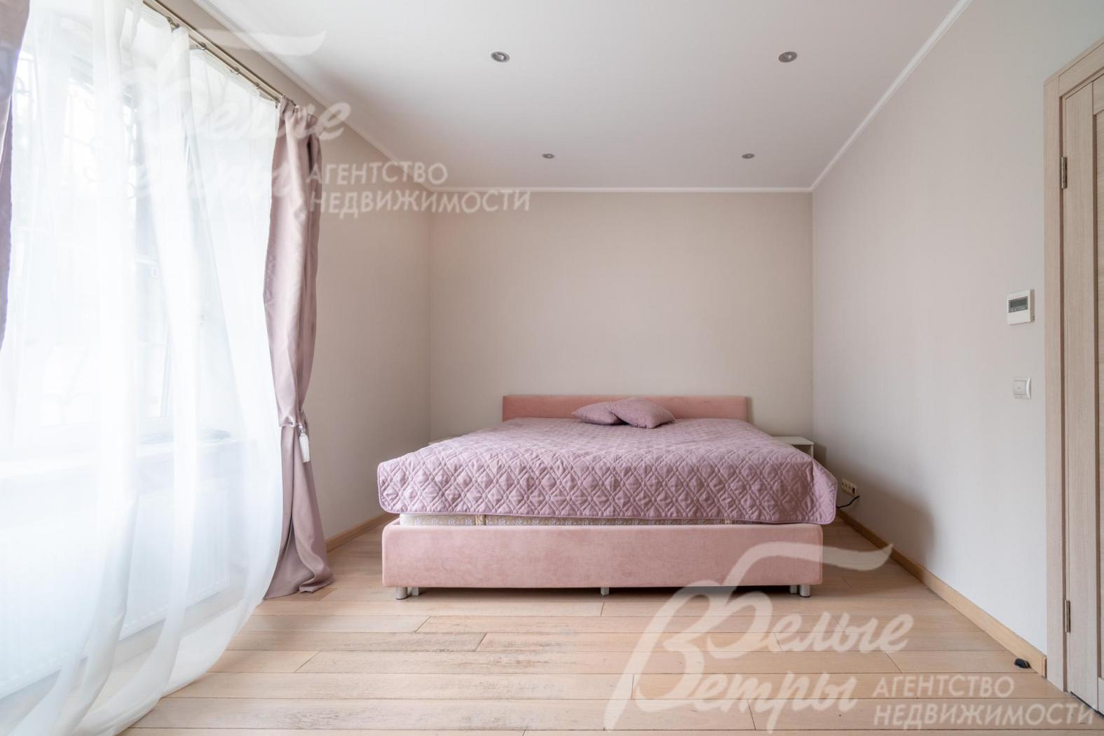 Одна из спален на втором этаже с собственным санузлом и большим окном