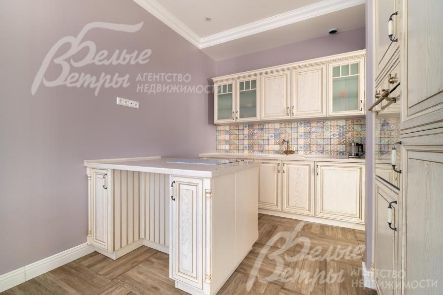 В кухне – гарнитур молочного цвета в классическом стиле с островом (бренд премиум-класса STORMER D'ART)