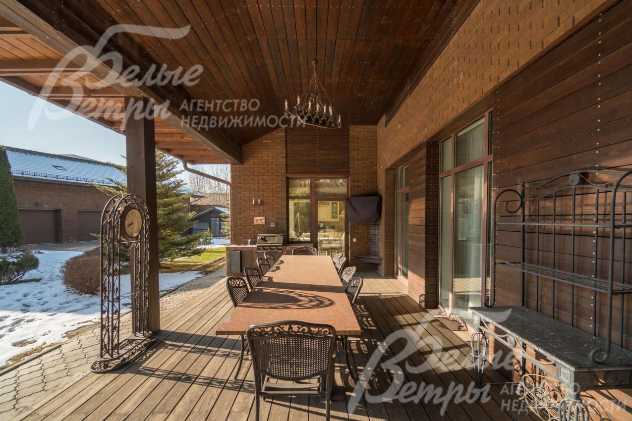 Крытая терраса основного дома с садовой мебелью и оборудованием для гриля