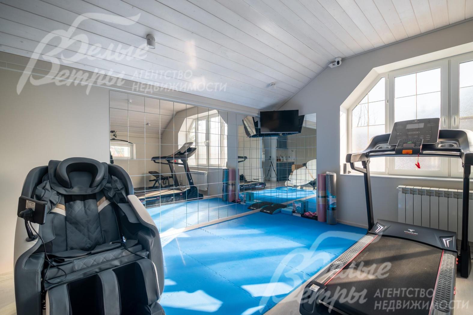 На втором этаже обустроен спортзал с тренажёрами и массажным креслом