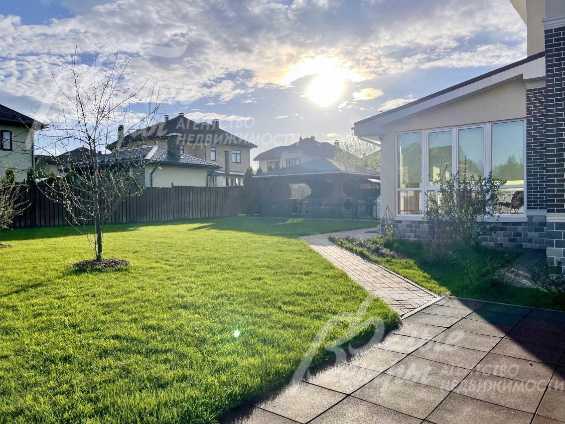 Ухоженный газон на участке, дорожки.