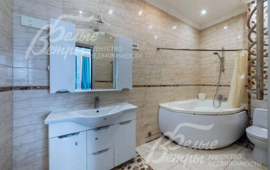 Санузел на втором этаже с угловой ванной, оформлен керамической плиткой