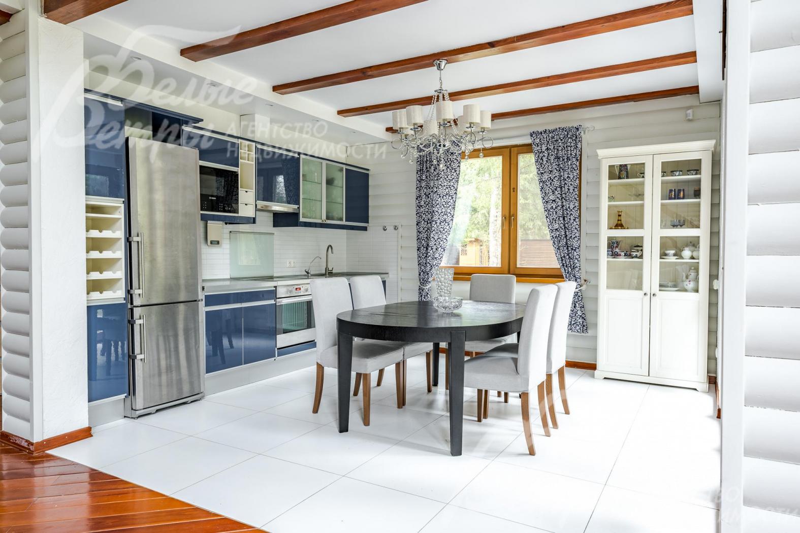 В кухне-столовой установлен стильный кухонный гарнитур со встроенной бытовой техникой