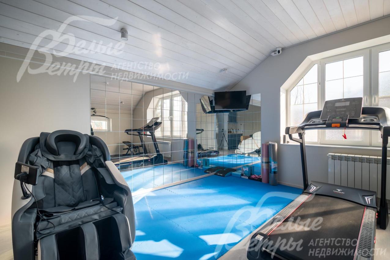На втором этаже обустроен спортзал с тренажёрами и массажным креслом