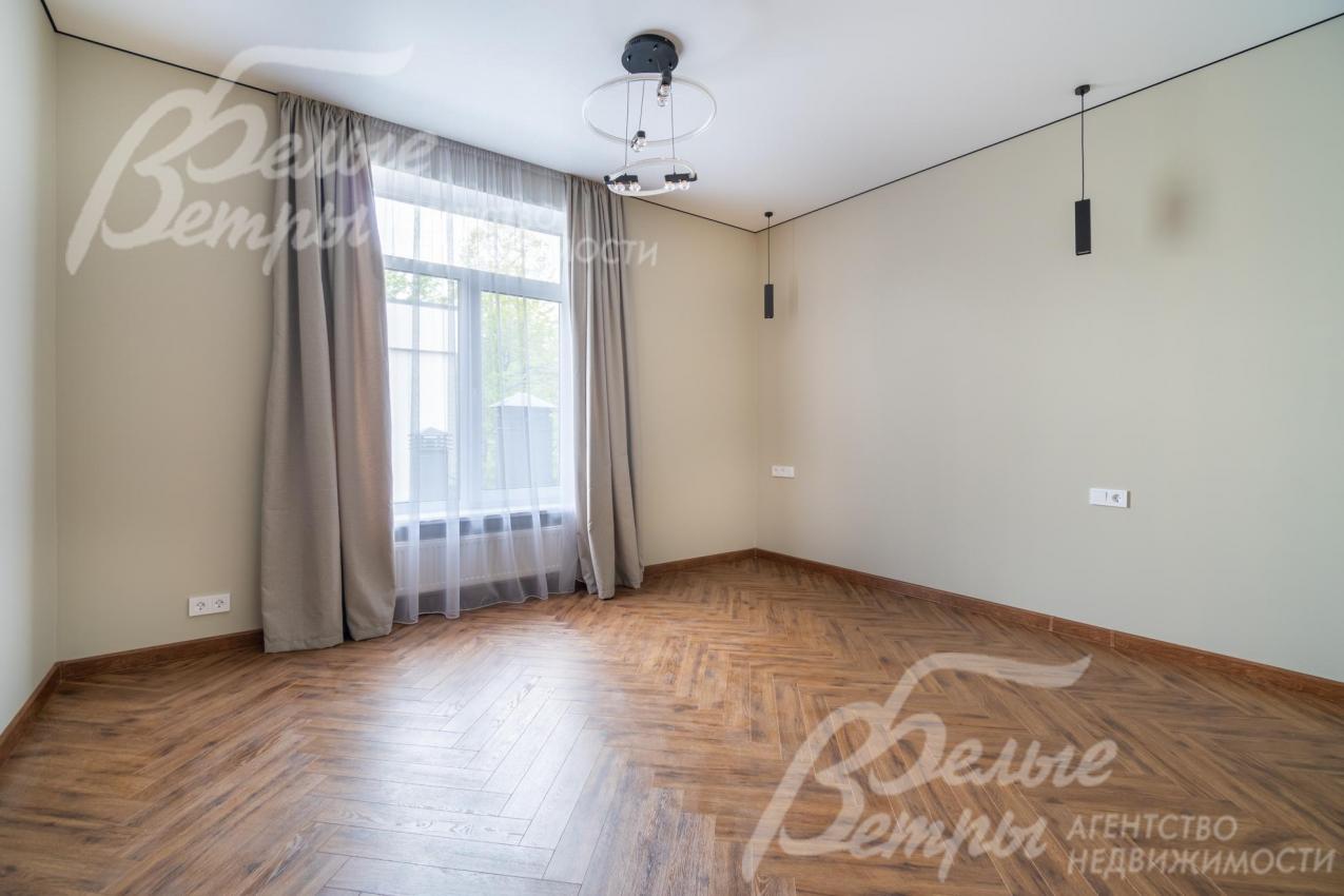 Одна из спален: установлено стильное чёрное трековое освещение, на полу - инженерная доска (кладка елочкой)