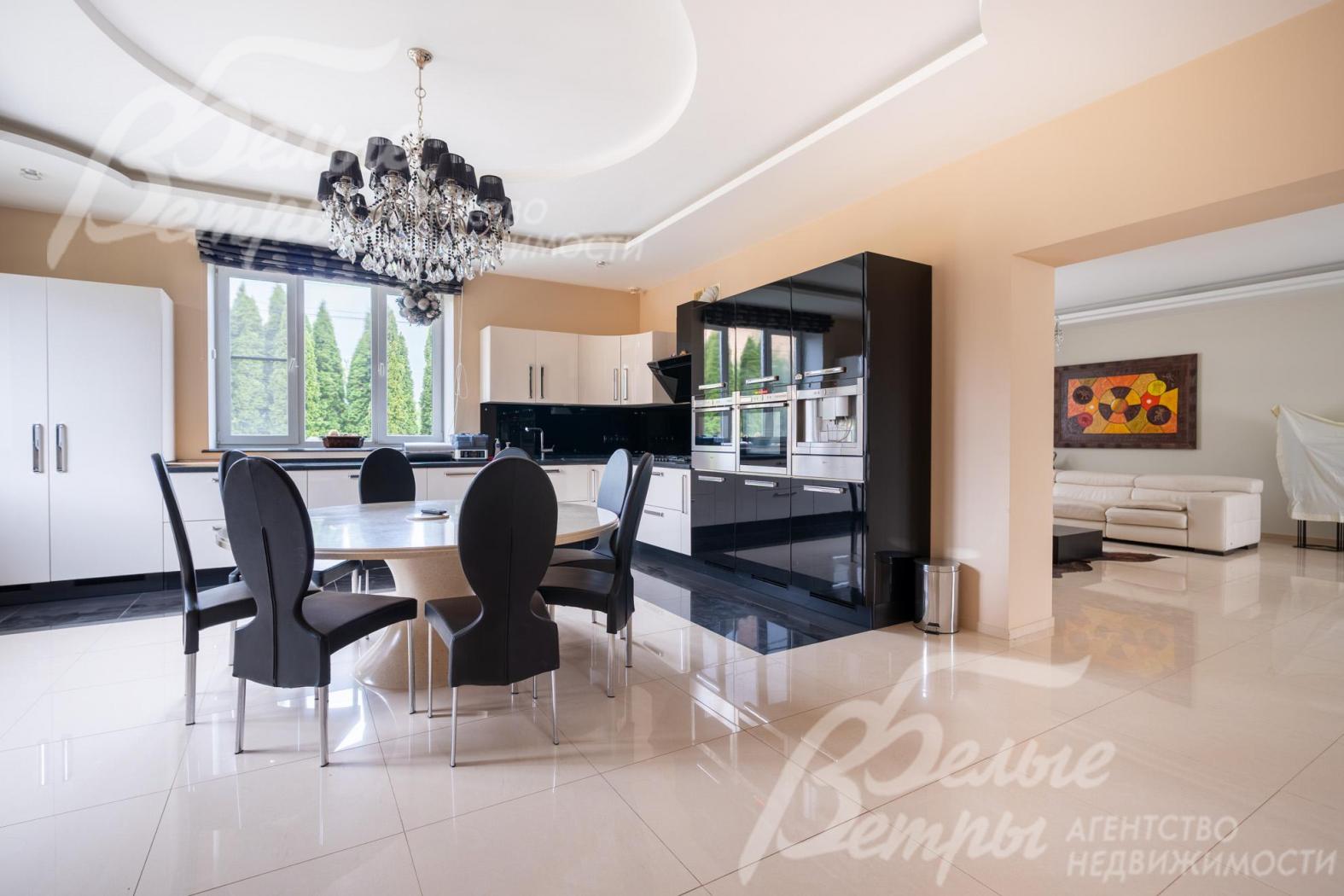 В кухне-столовой - обеденная группа с большим круглым столом