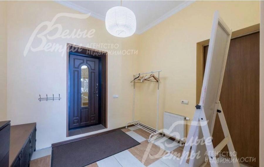 Прихожая оформлена в светлых, тёплых тонах, установлена контрастная входная дверь с декоративной стеклянной вставкой