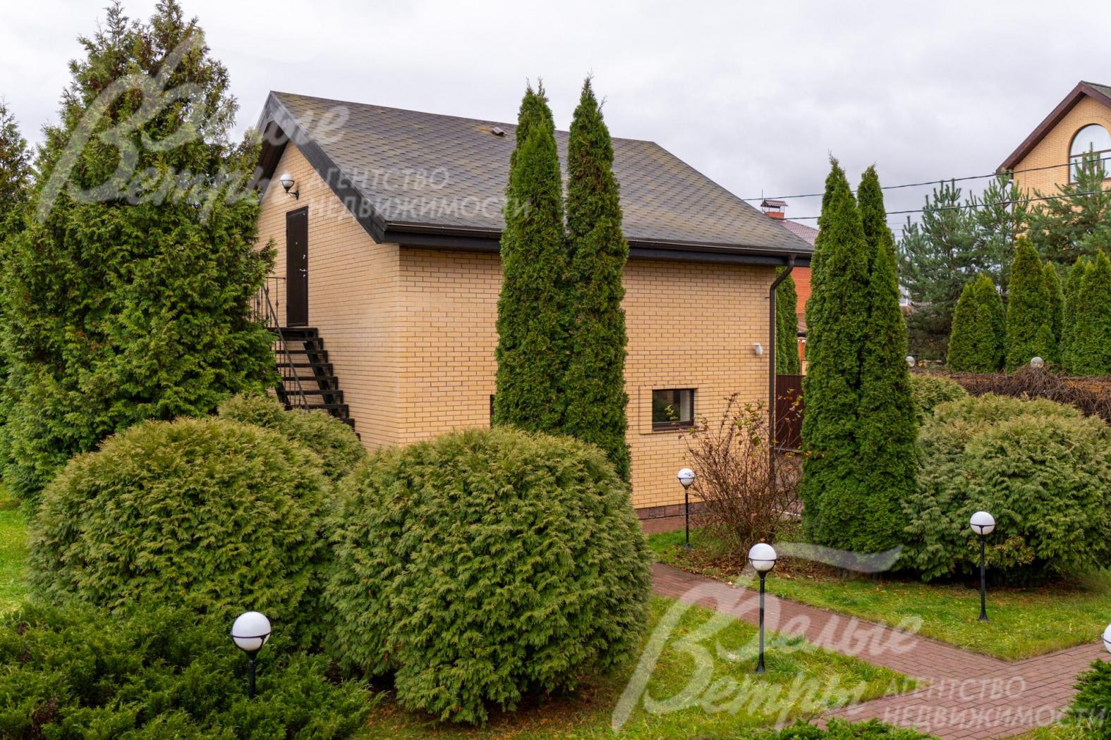 У главного дома высажены высокие стройные симметричные туи и кустарники со сформированной шарообразной формой