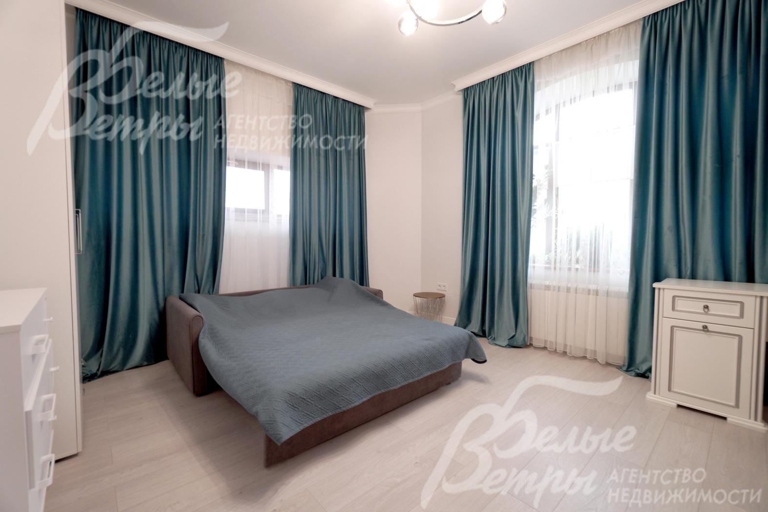 Одна из спален на втором этаже: на полу - ламинат высокого класса, окна декорированы контрастными шторами