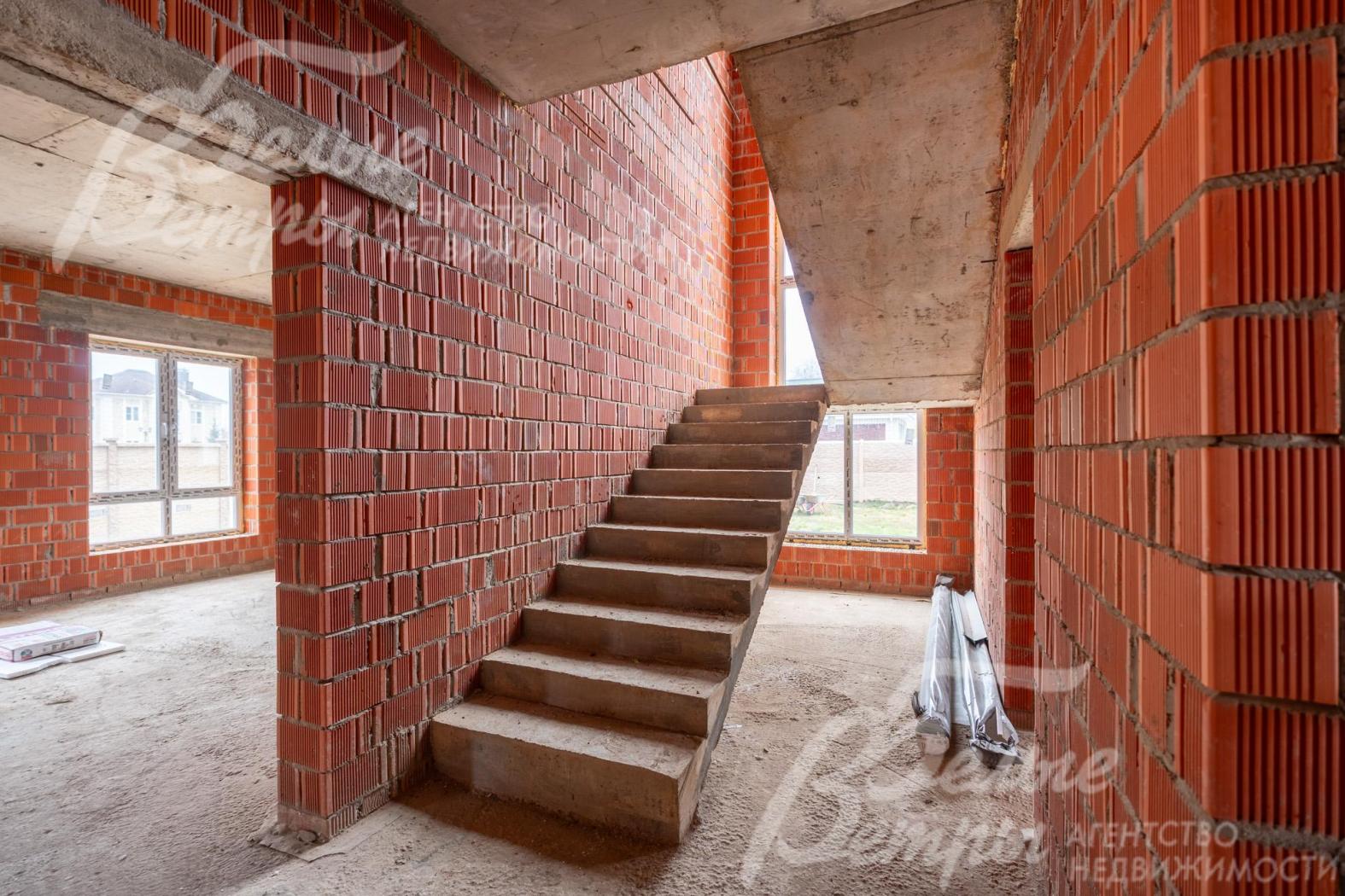 На второй этаж ведёт лестница на бетонном основании, на лестничном пролёте - окно в два этажа