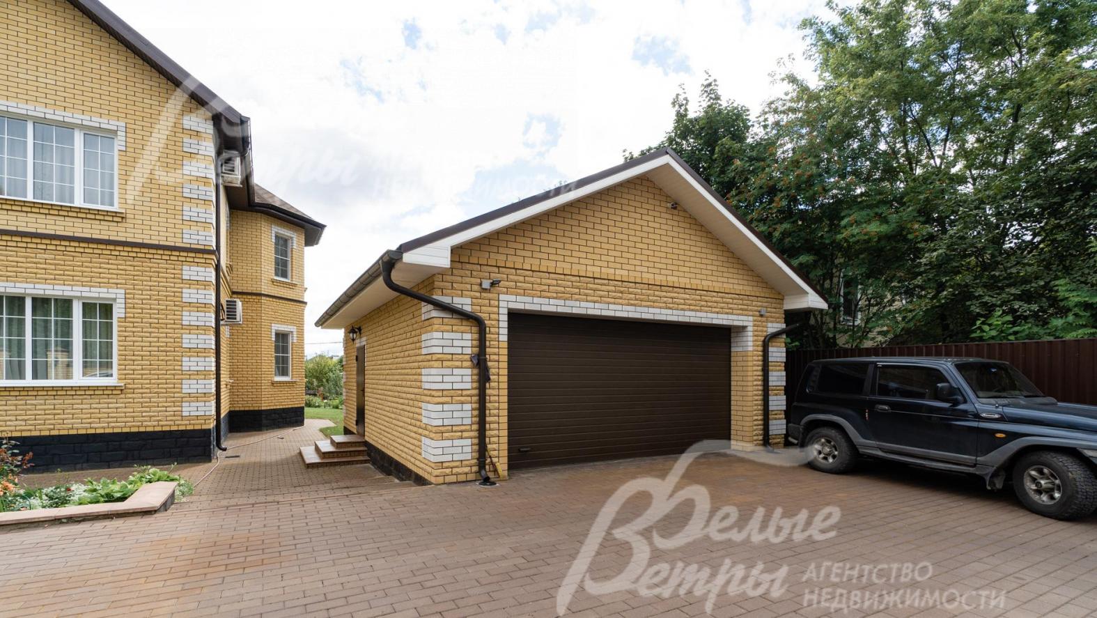 Гараж на 2 а/м в едином стиле с домом. Перед ним - большая парковка