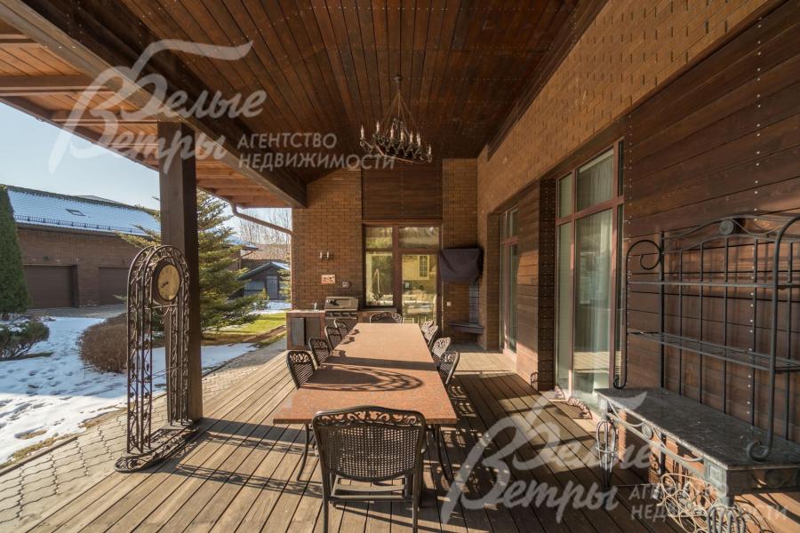 Крытая терраса основного дома с садовой мебелью и оборудованием для гриля