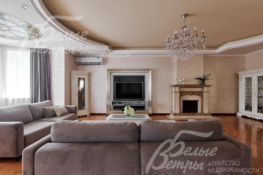 В гостиной установлен широкоформатный телевизор напротив диванной группы