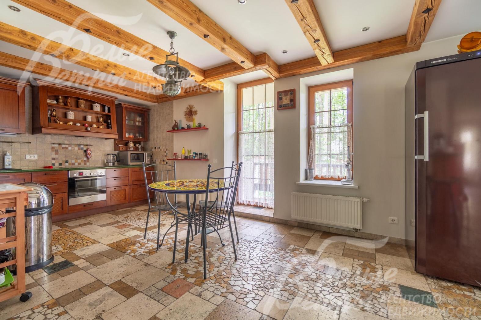 На кухне - гарнитур с фасадами из массива дерева (вишня), встроенная бытовая техника, дизайнерский обеденный стол