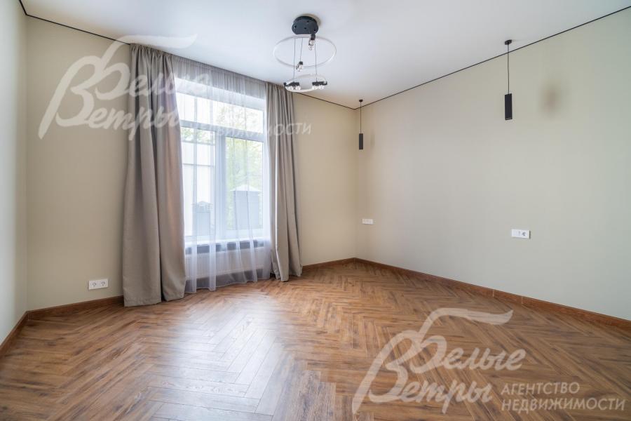 Одна из спален: установлено стильное чёрное трековое освещение, на полу - инженерная доска (кладка елочкой)