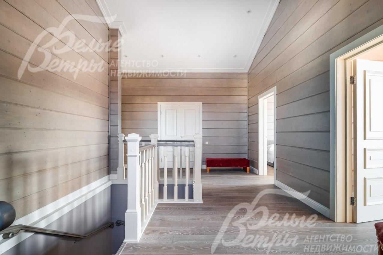 Холл второго этажа: стены оформлены тонированным брусом с противопожарной обработкой и покрытием премиальной краской Sikkens