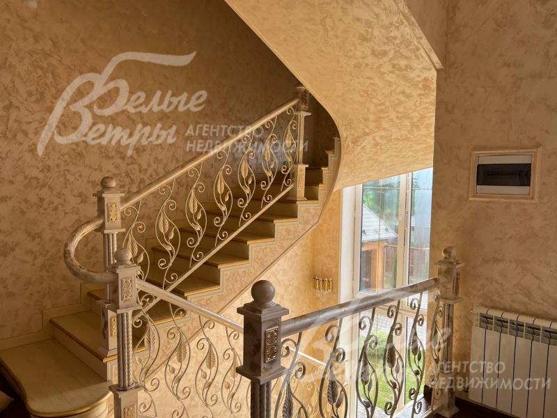 Красивая лестница с коваными перилами.