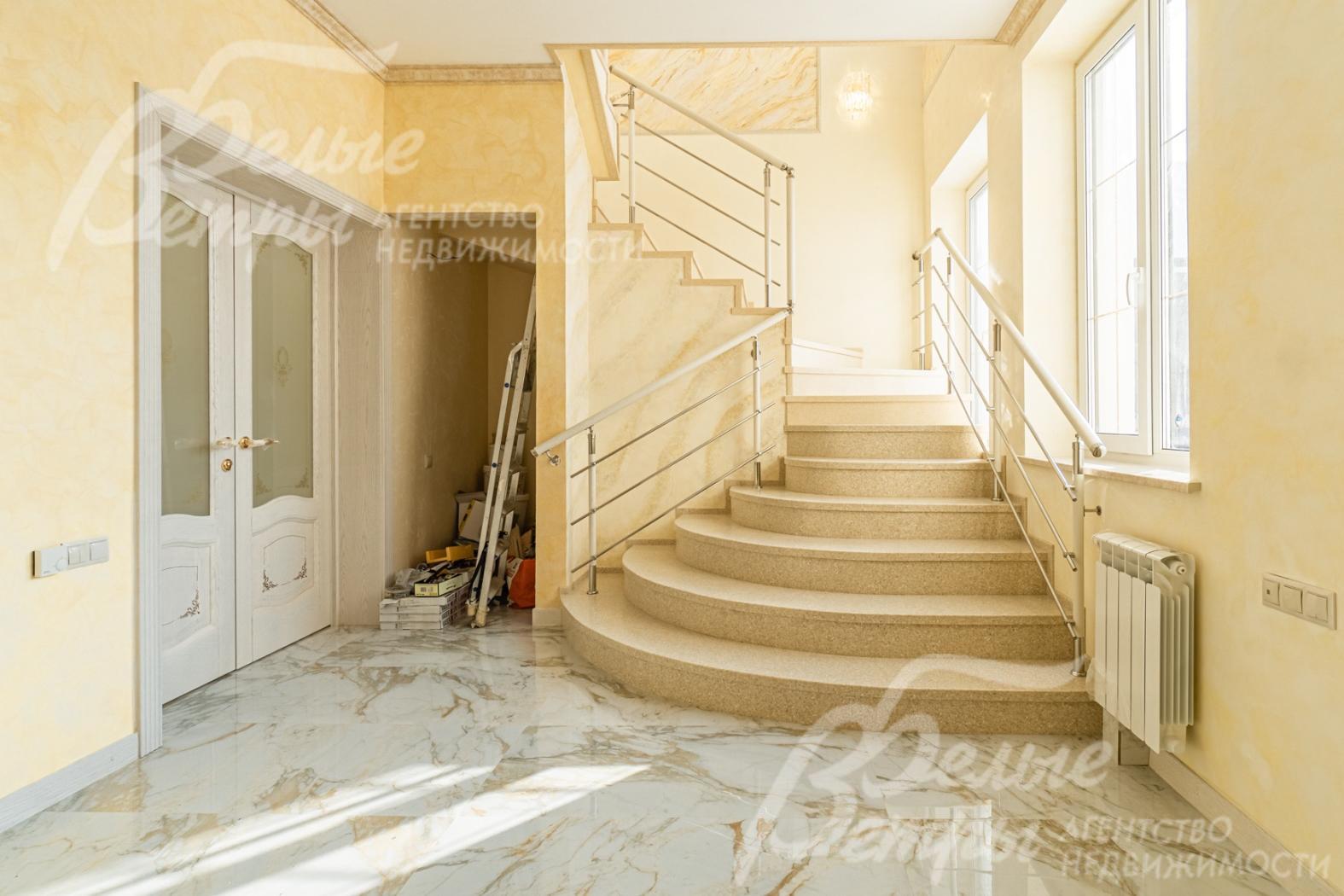 Оригинальная лестница на бетонном основании, ступени облицованы искусственным камнем двух цветов.